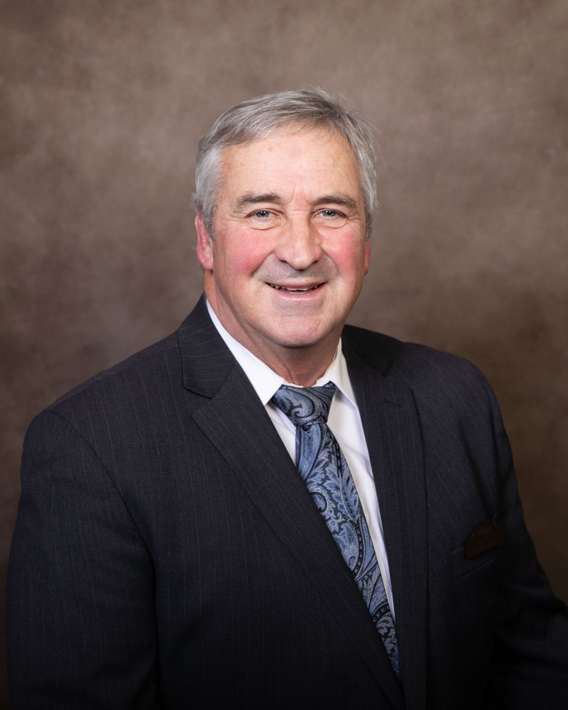 A man in a suit and tie is smiling for the camera.