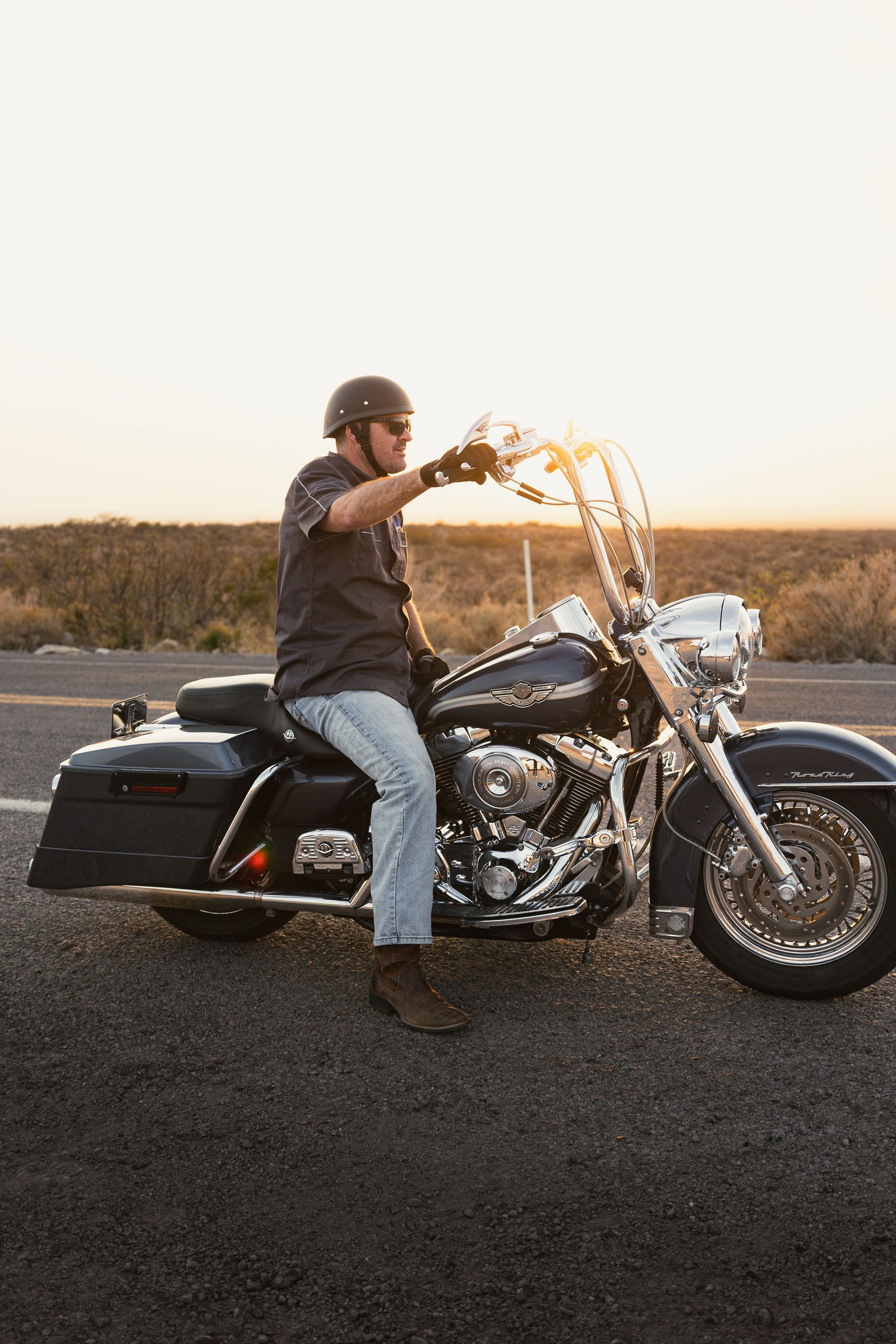 Person on a black motorcycle spraying water outdoors at sunset
