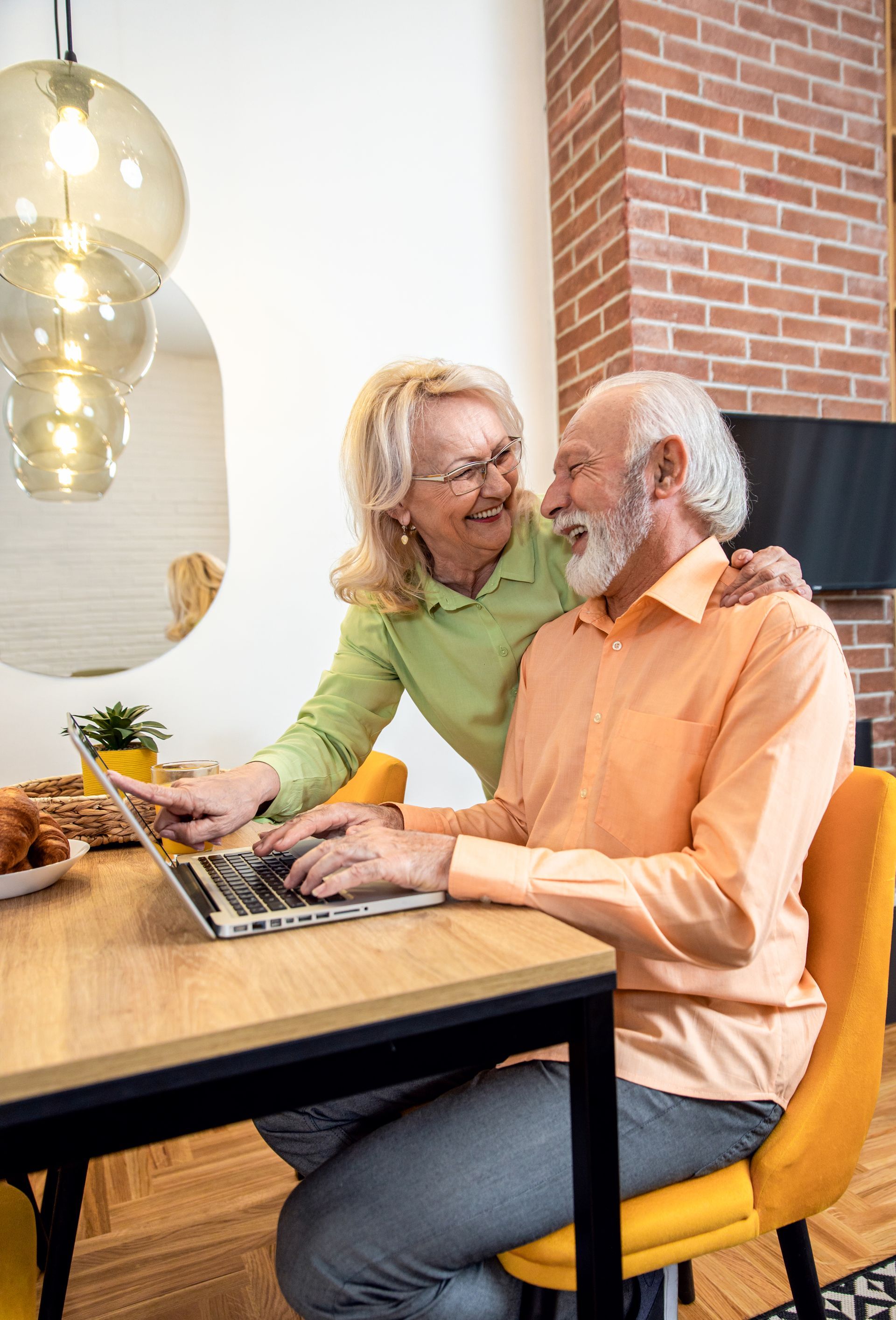 Couple talking at a table with a laptop in a bright modern cafe