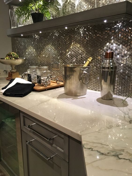 Un comptoir de cuisine avec un seau de champagne et un shaker dessus.