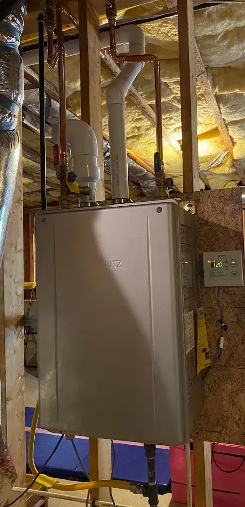 Metal electrical panel mounted on an unfinished wall with exposed framing and insulation in a utility space