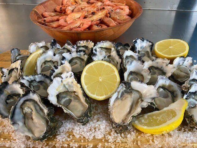 A Cutting Board Topped with Oysters — Stones Oysters & Shed Takeaway in Harrington, NSW
