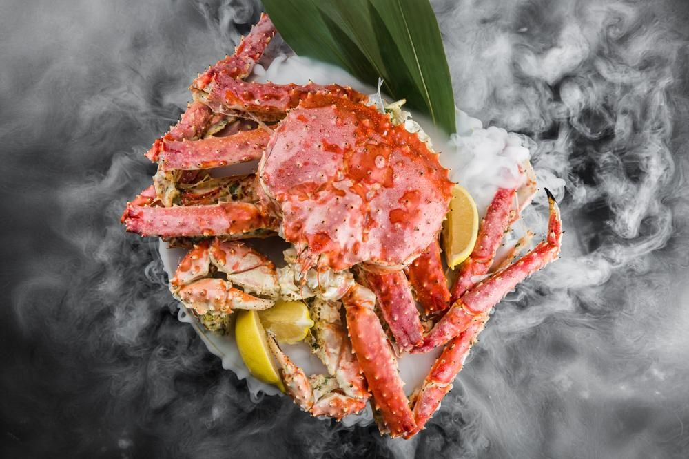A Large Crab Is Sitting on A Plate — Stones Oysters & Shed Takeaway in Harrington, NSW