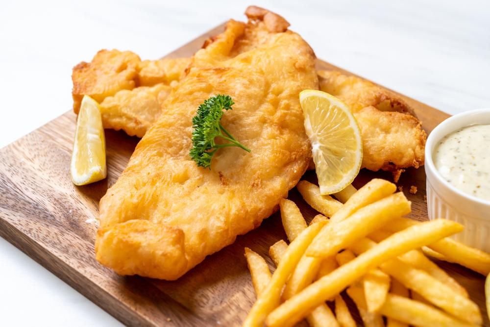 A Wooden Cutting Board Topped with Fried Fish — Stones Oysters & Shed Takeaway in Harrington, NSW