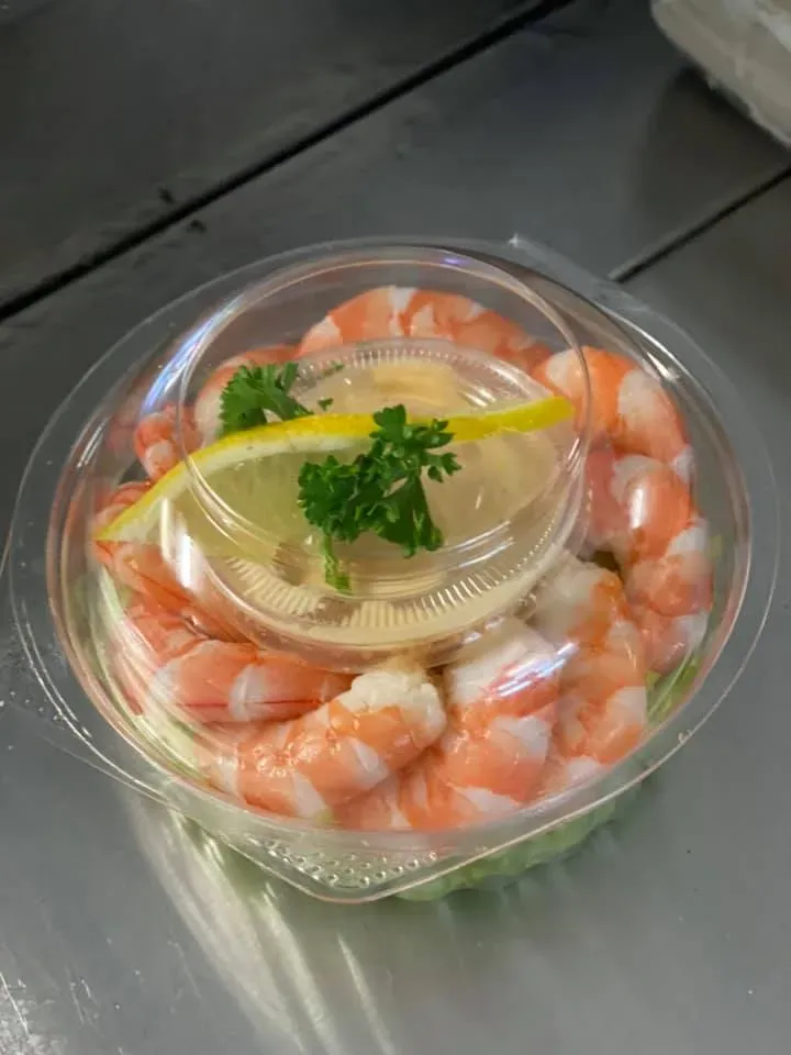 A Plastic Container Filled With Shrimp and Sauce on a Table — Stones Oysters & Shed Takeaway in Taree, NSW