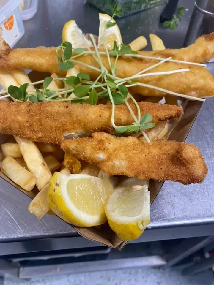 A Tray of Fish and Chips With Lemon Slices on a Table — Stones Oysters & Shed Takeaway in Taree, NSW