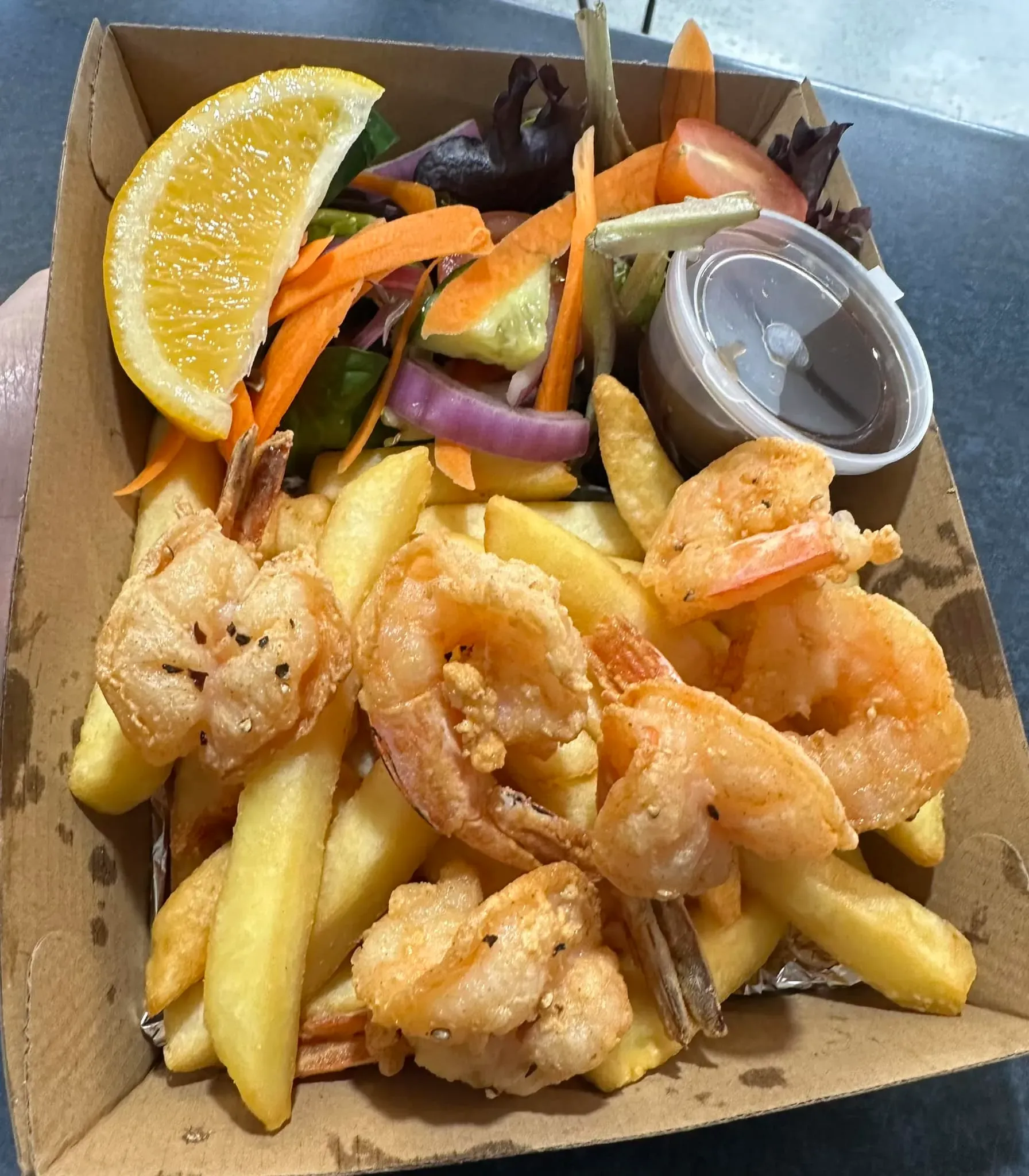 A Person is Holding a Box of Shrimp and French Fries — Stones Oysters & Shed Takeaway in Harrington, NSW