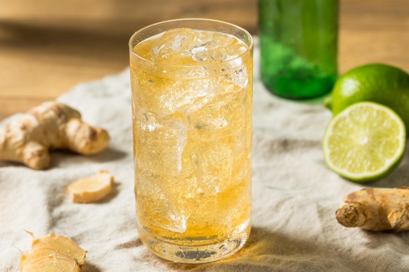 A Glass of Ginger Ale with Ice and Limes on A Table — Stones Oysters & Shed Takeaway in Harrington, NSW