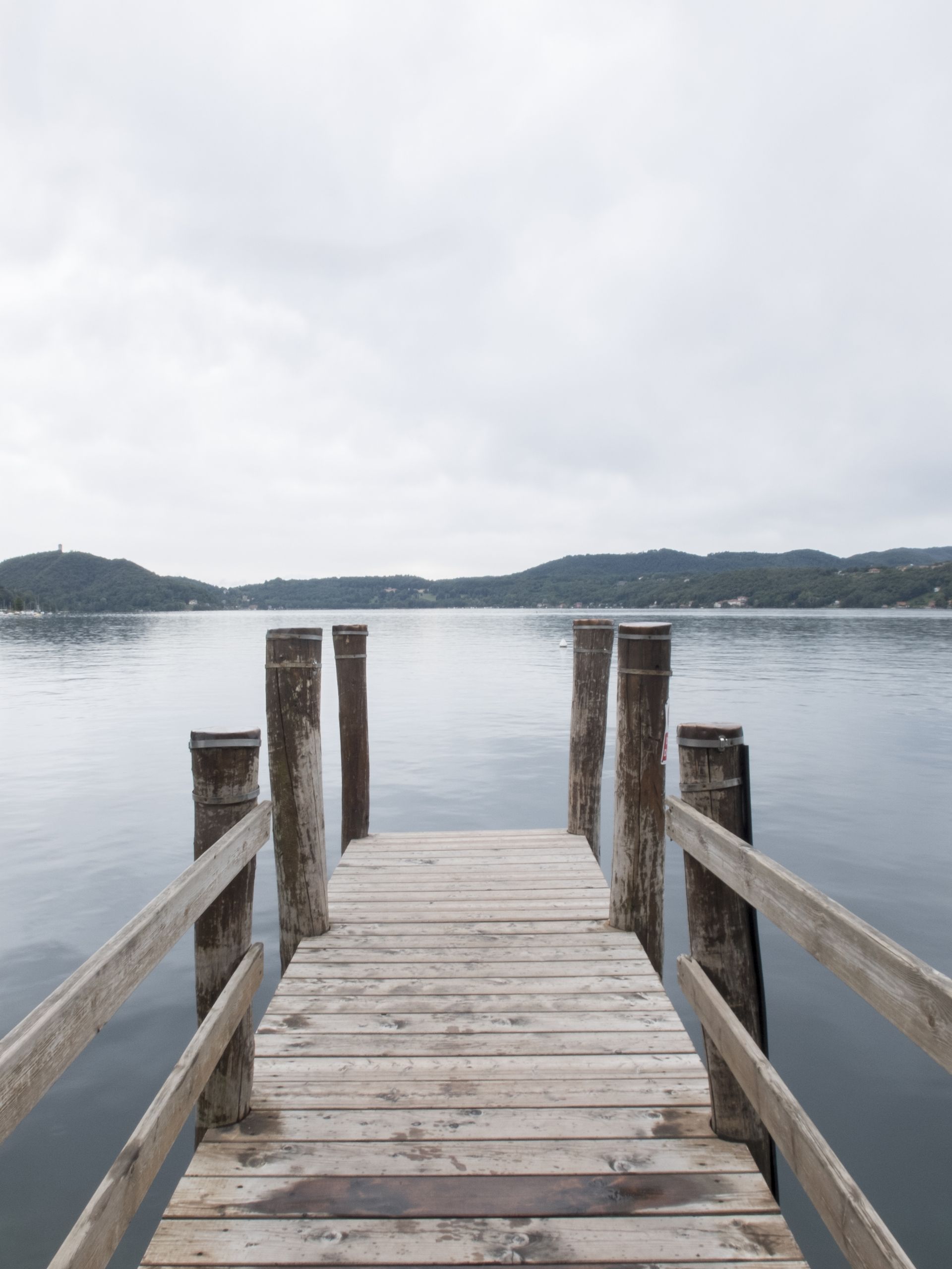A wooden dock leading into a lake with mountains in the background — Stones Oysters & Shed Takeaway in Harrington, NSW