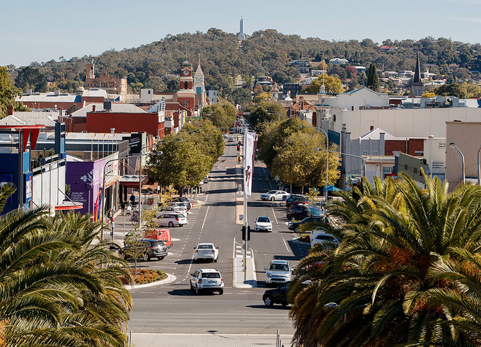 An aerial view of a city street with palm trees in the foreground