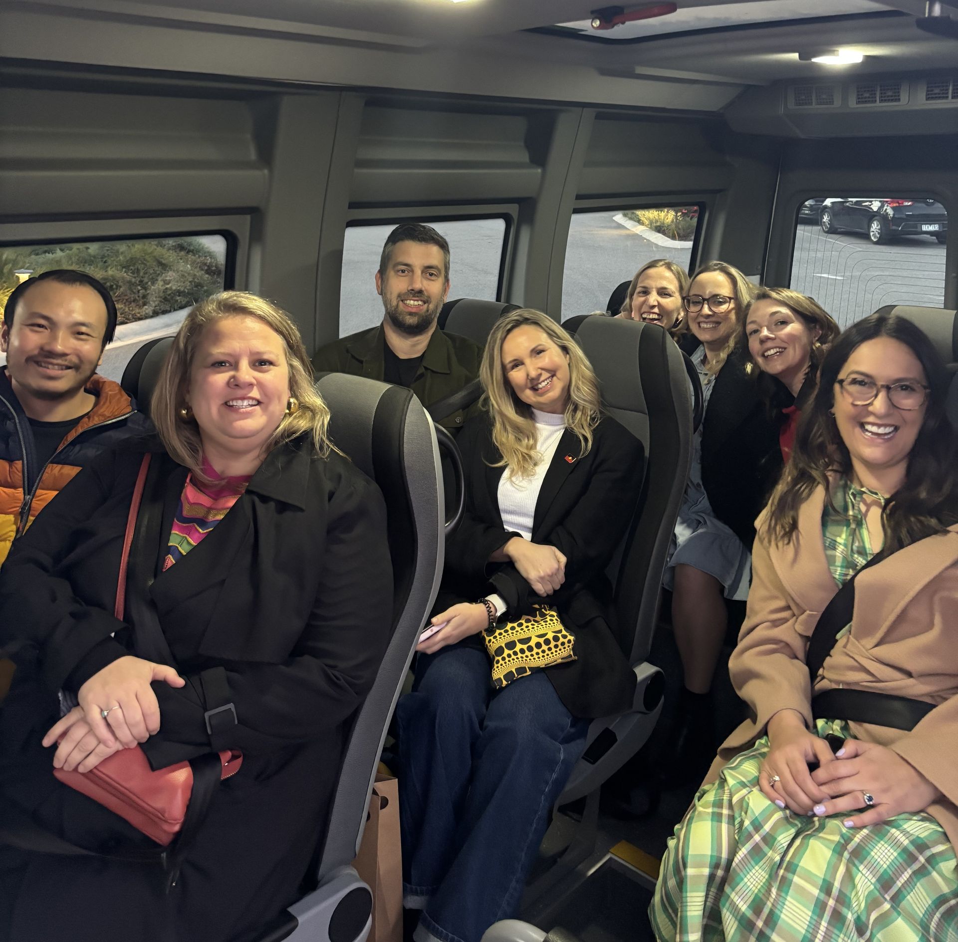A group of smiling people on board a Ticket 2 Ride minibus.