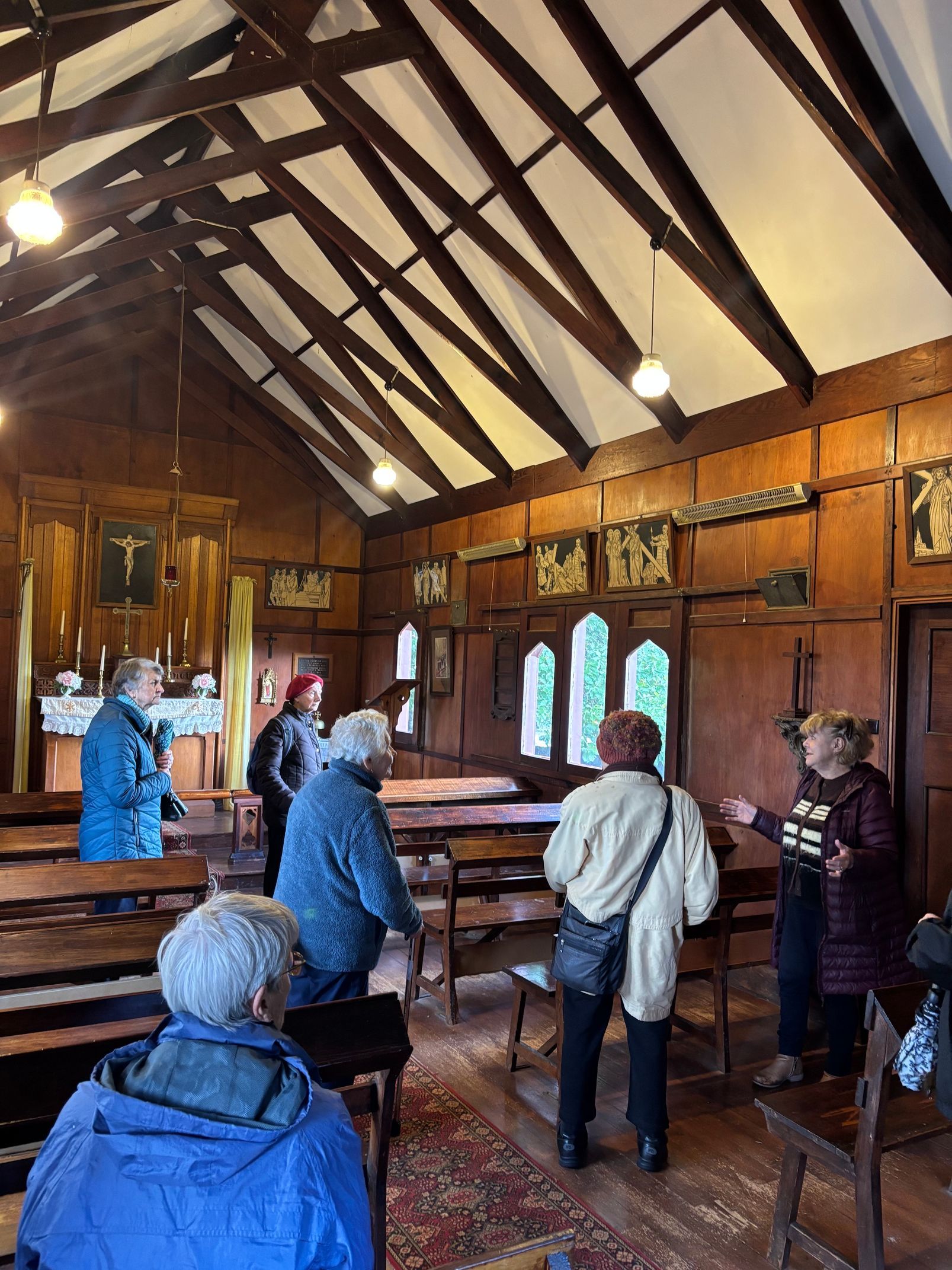 A group of people inside an old church as part of a seniors day trip.