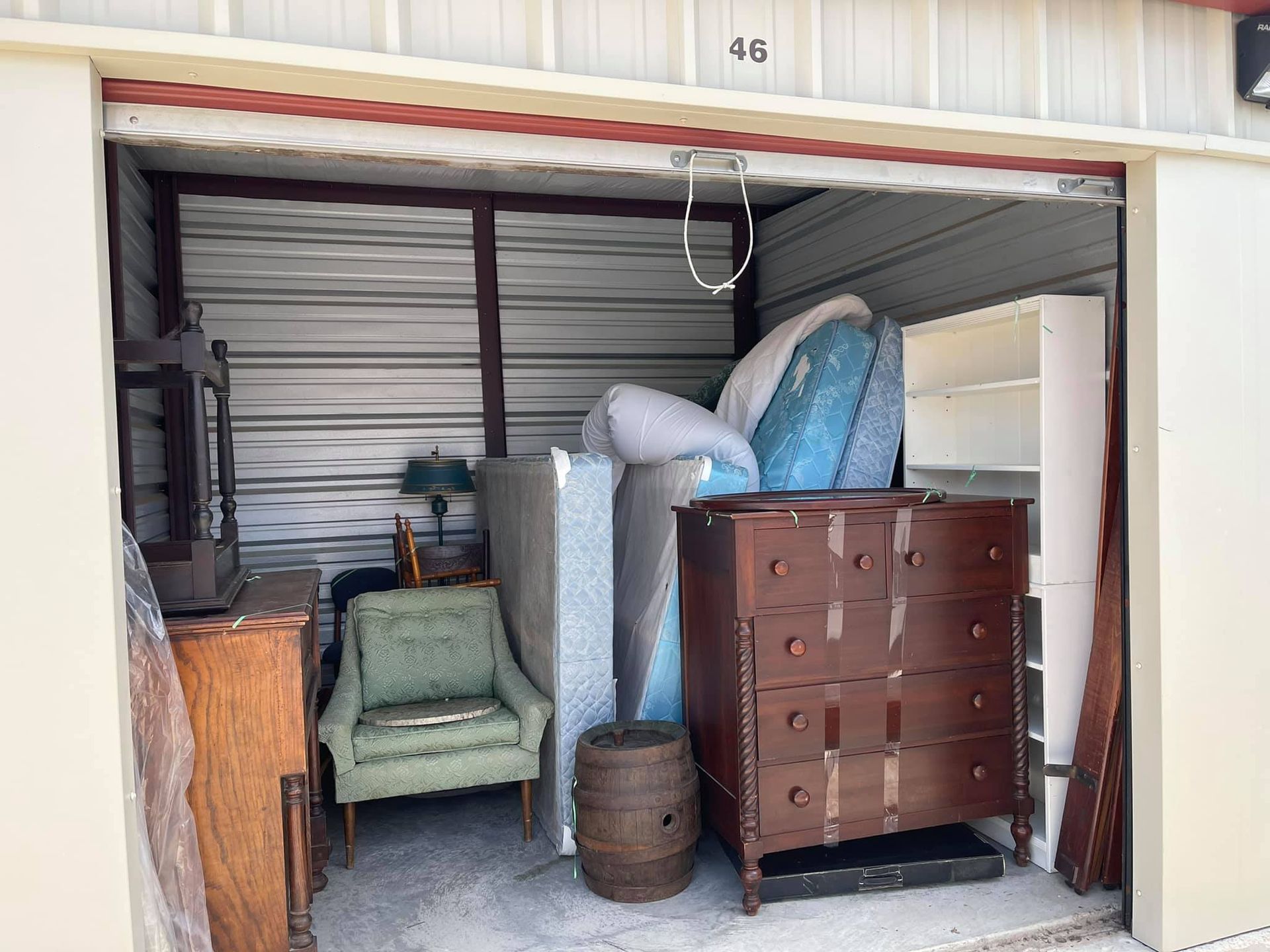 A storage unit filled with furniture and mattresses.