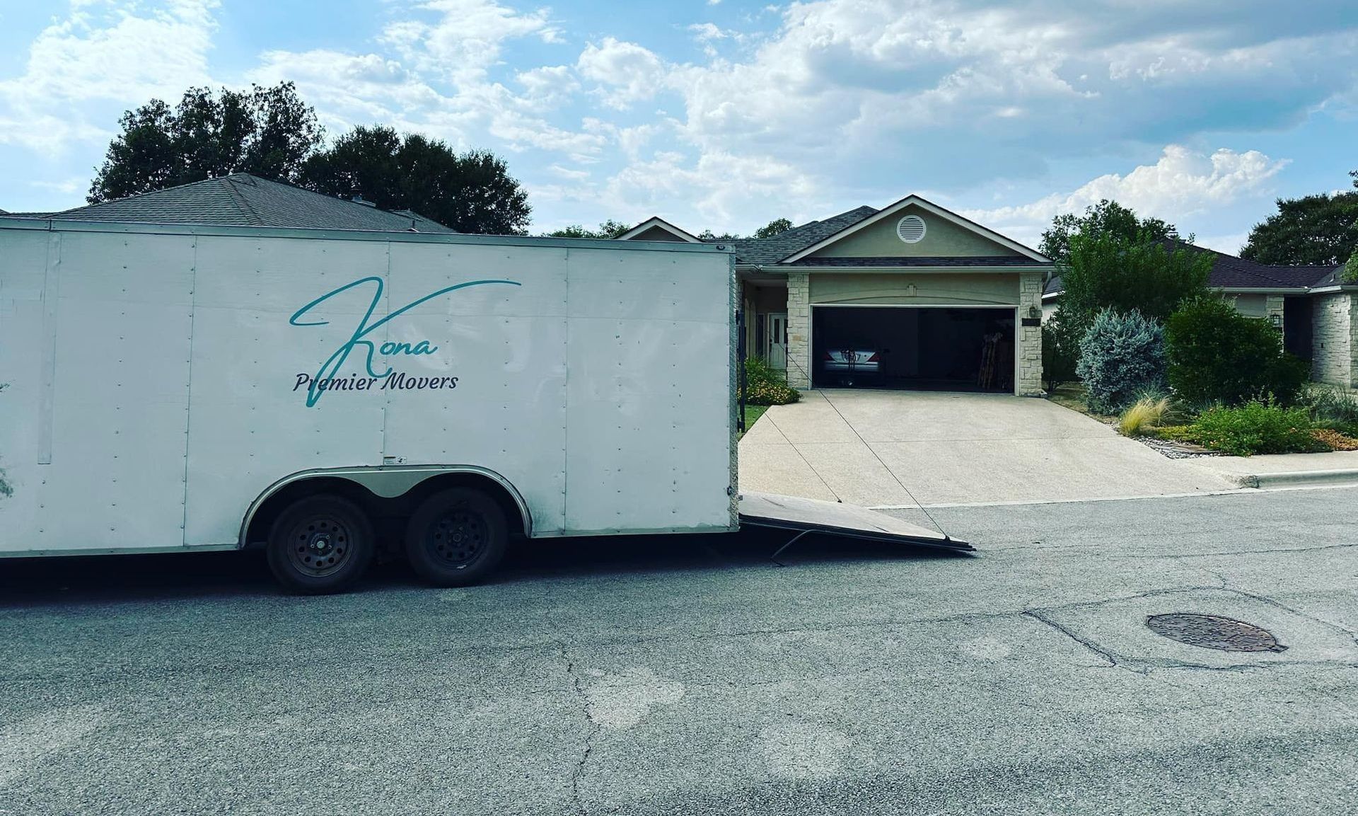 A white trailer is parked in front of a house.