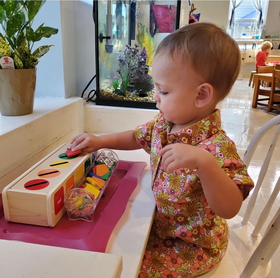 A little boy is playing with a wooden toy