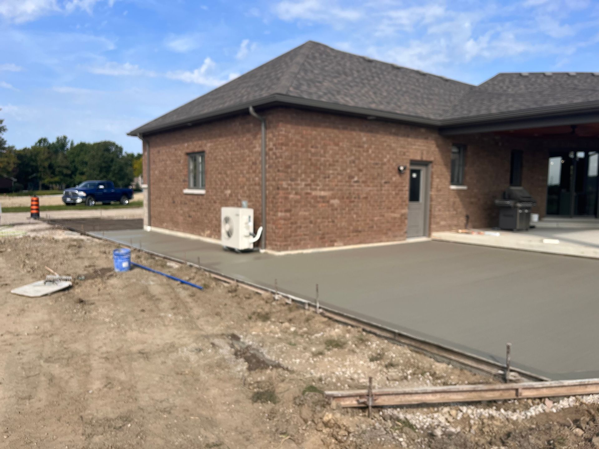 A brick house with a concrete driveway in front of it.