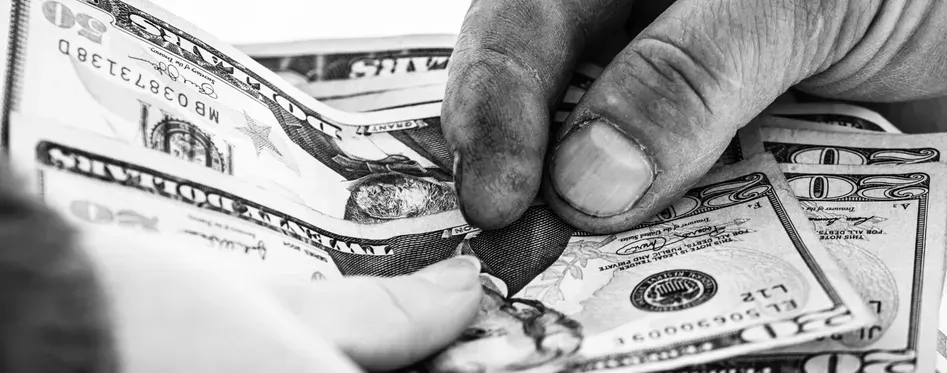 A black and white photo of a person counting out the tip for a fishing charter in Panama City Beach, FL.