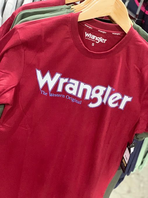 A Red Wrangler T-Shirt Is Hanging on A Wooden Hanger — Country Charm in Charmhaven, NSW