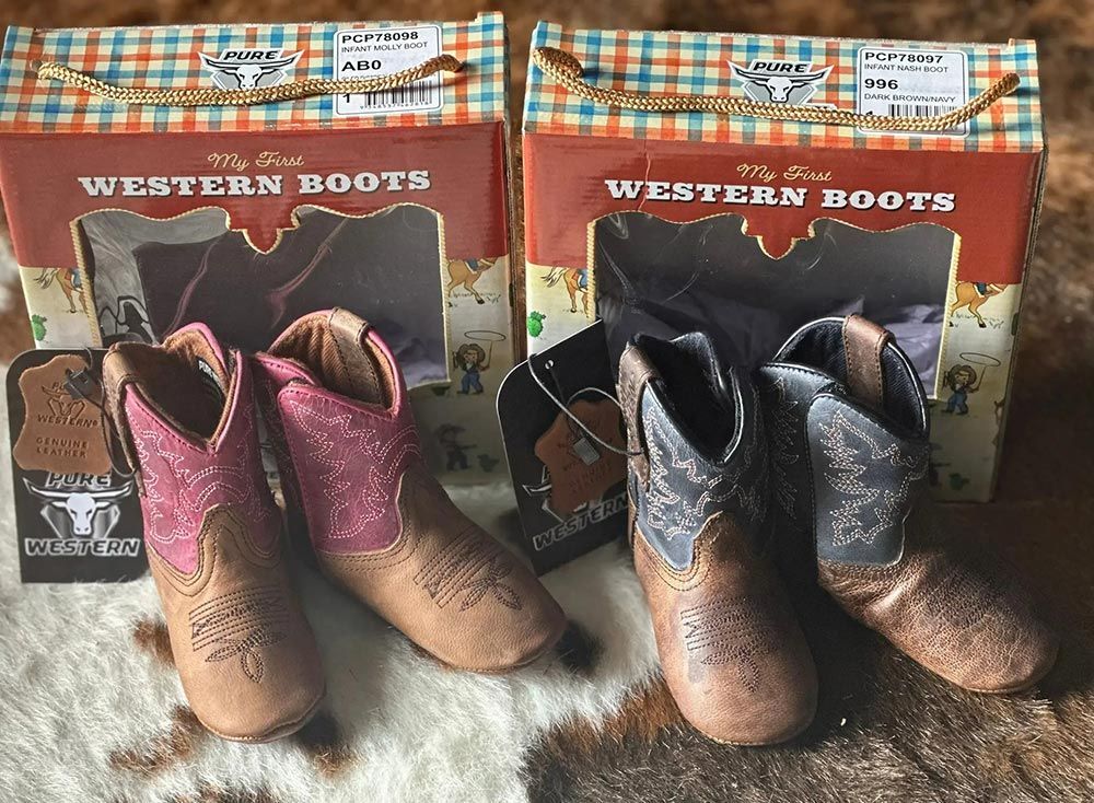 Two Boxes of Baby Cowboy Boots Are Sitting on A Blanket — Country Charm in Charmhaven, NSW