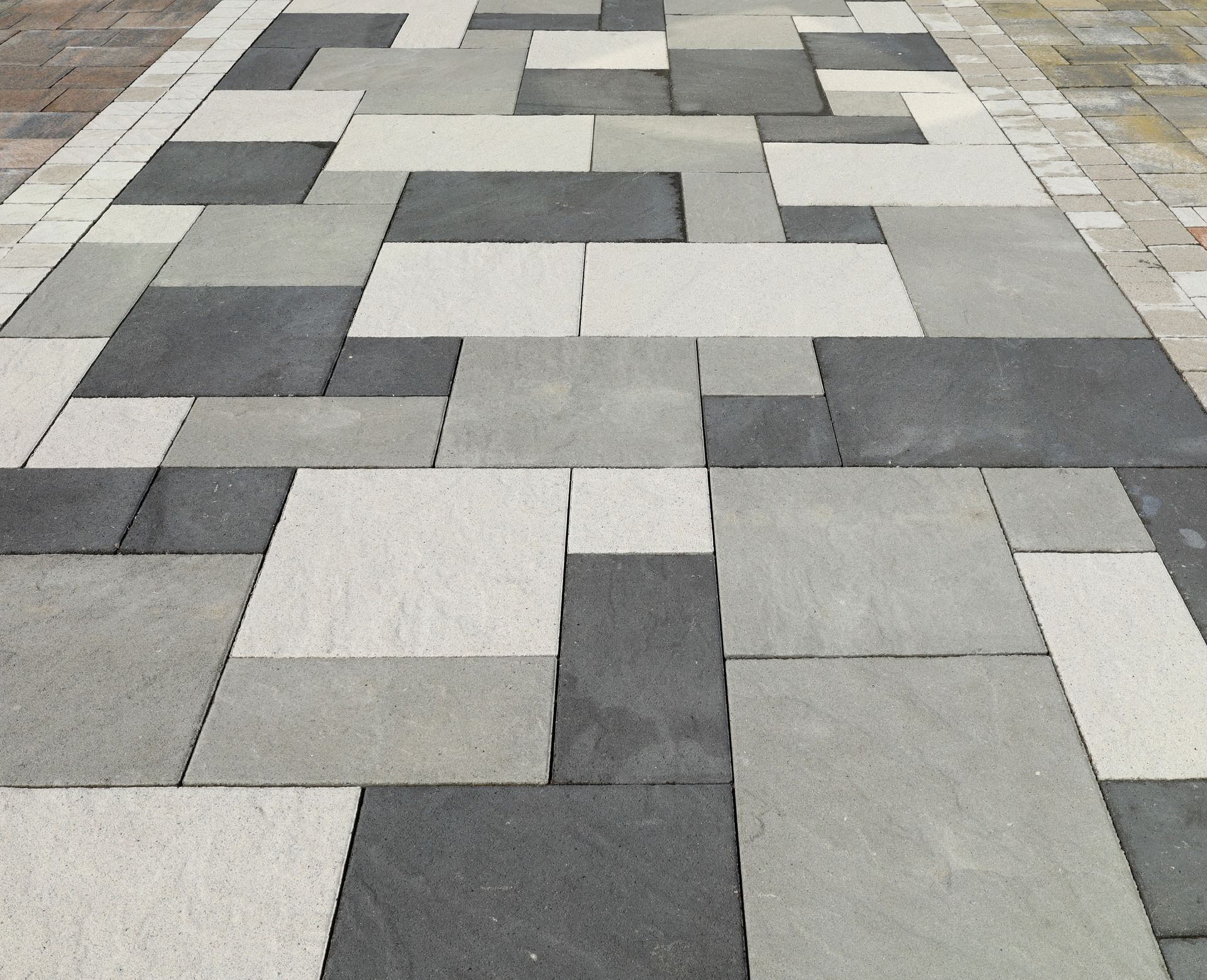 Gray and white patterned sidewalk pavers in a geometric arrangement