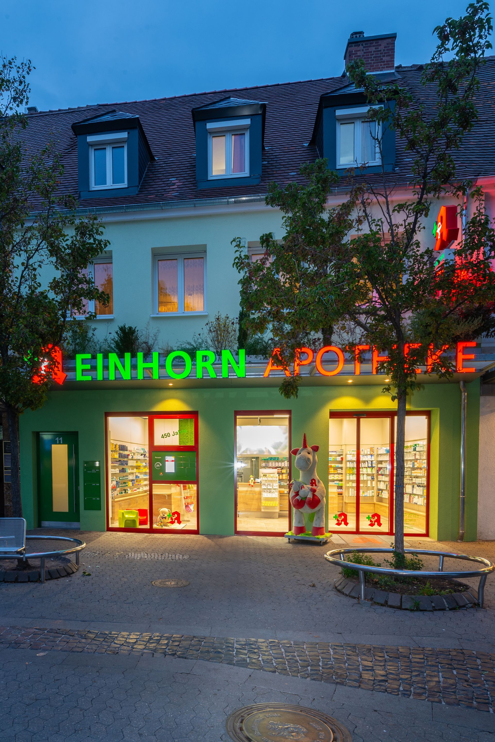 Grüne Ladenfront mit Leuchtreklame