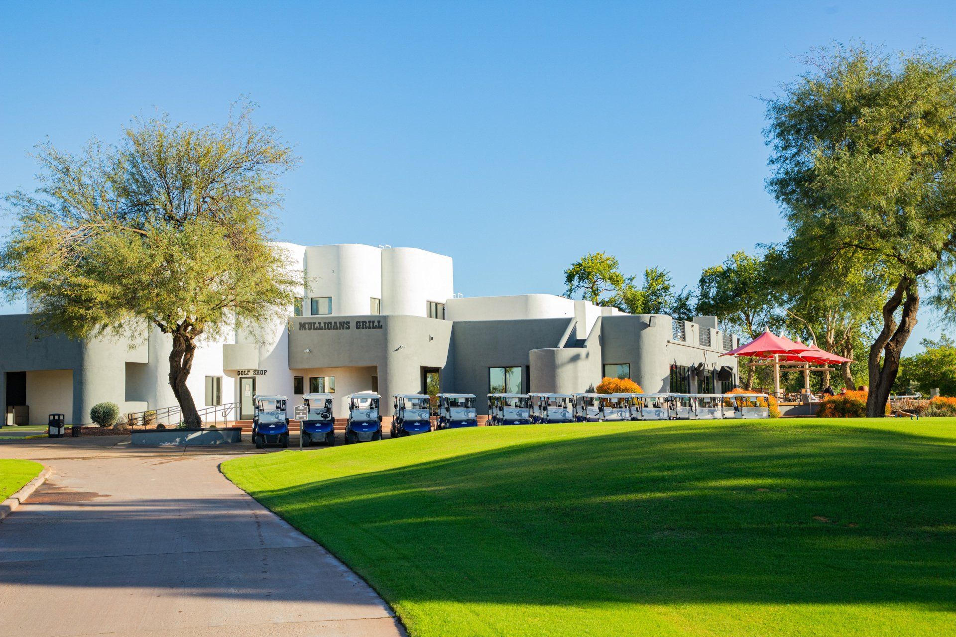 A row of golf carts are parked in front of a large building