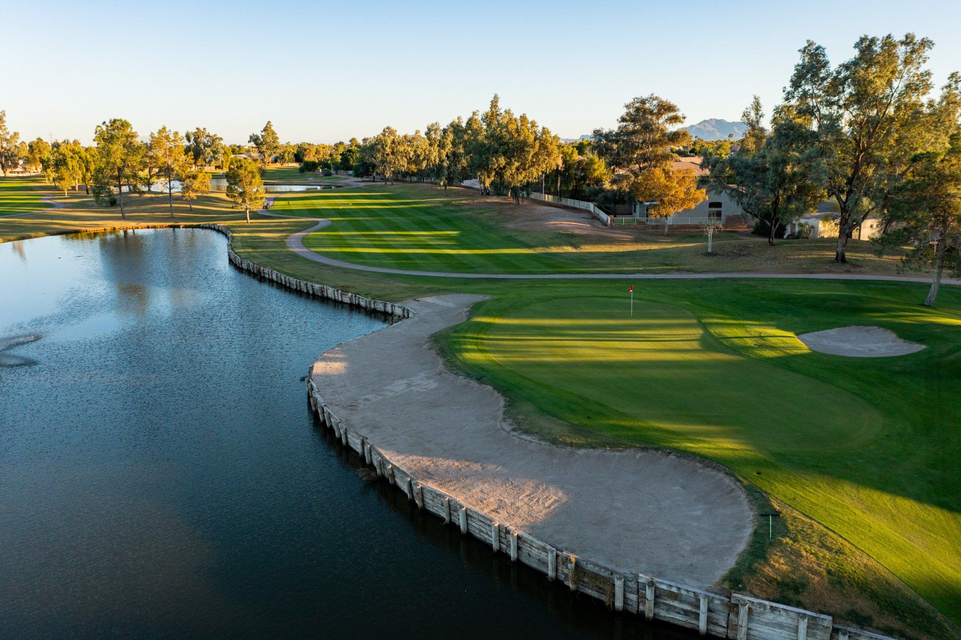 An aerial view of a golf course with a lake in the middle.