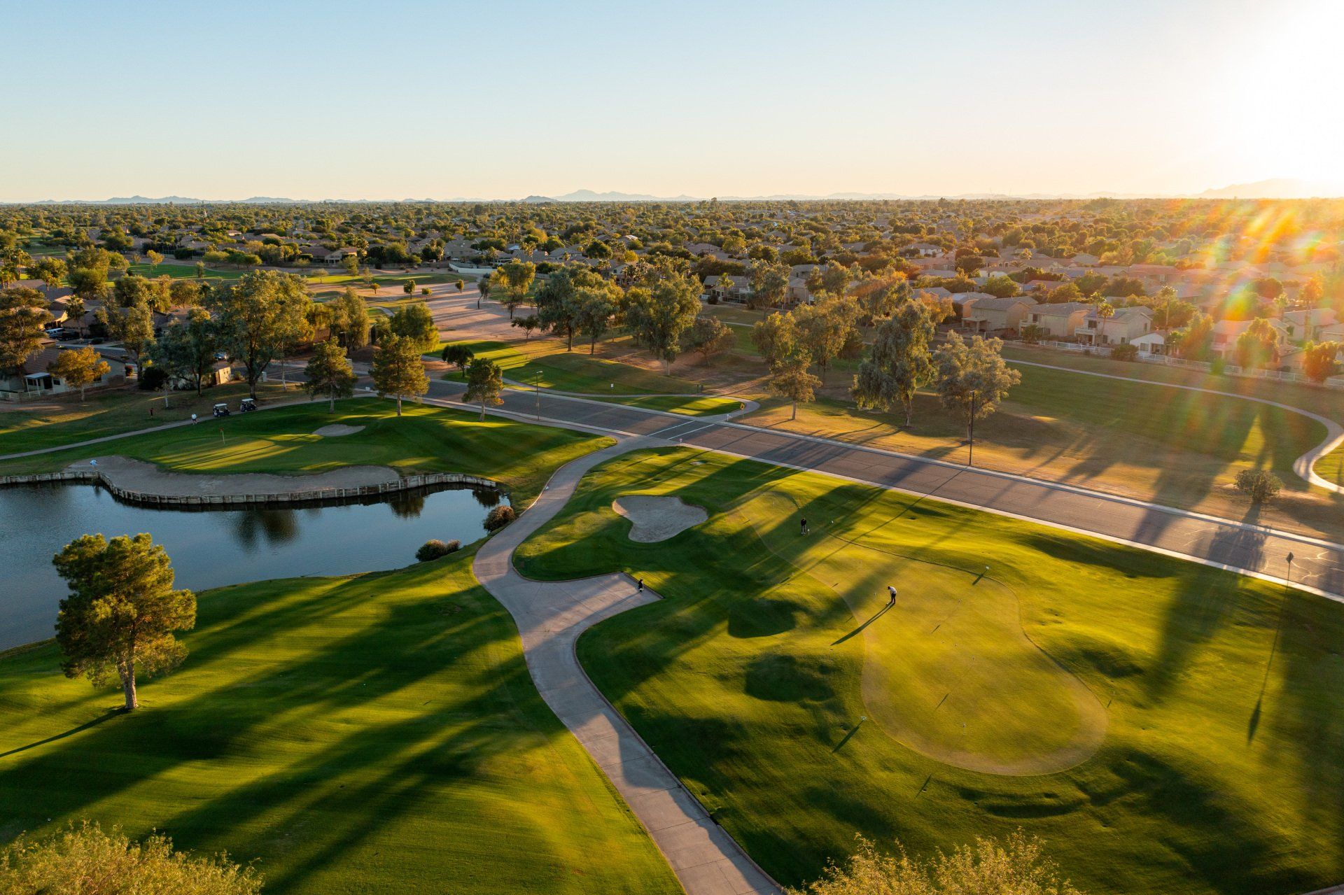 An aerial view of a golf course with a lake in the middle of it.