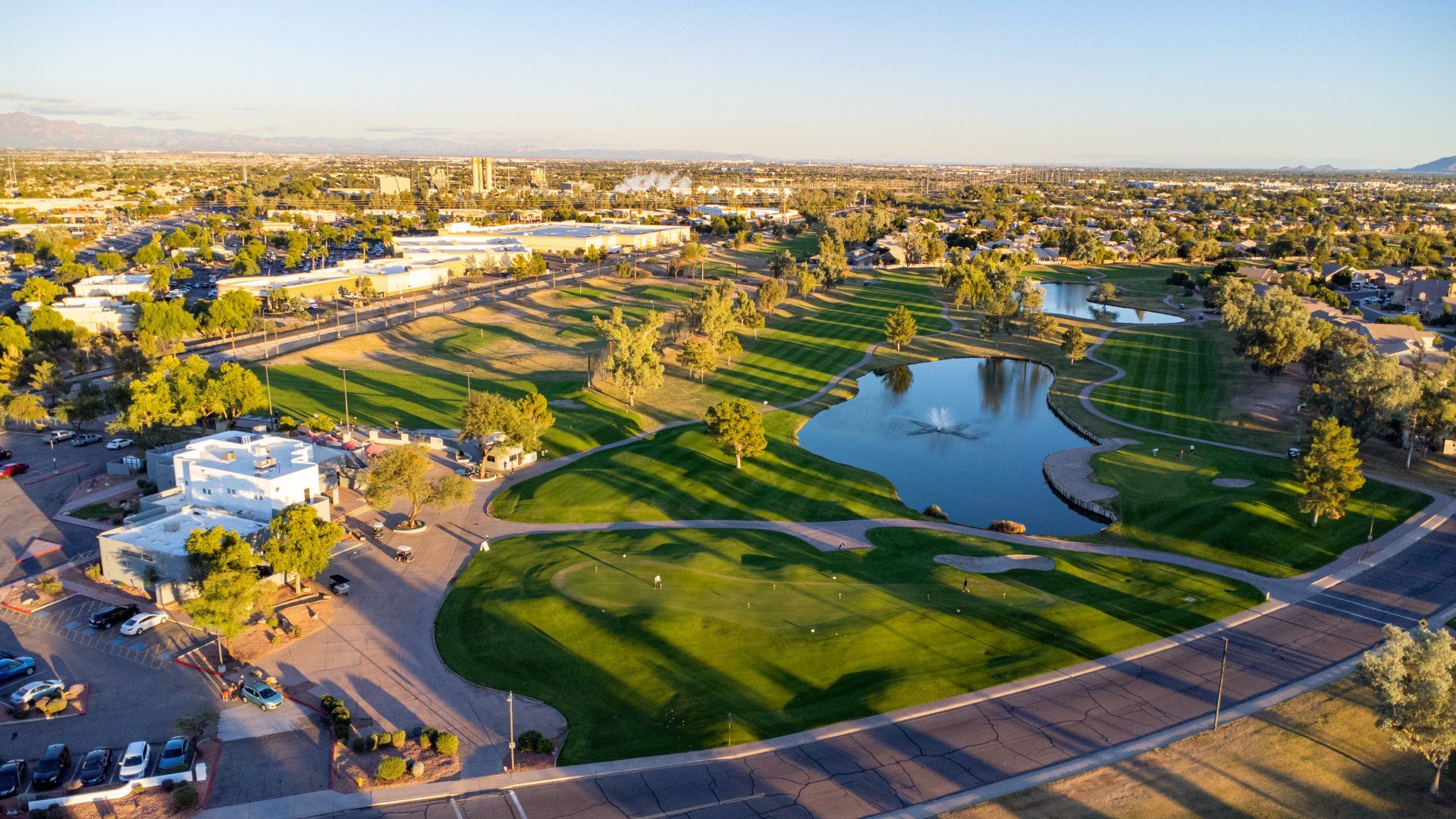 An aerial view of a golf course with a lake in the middle of it.