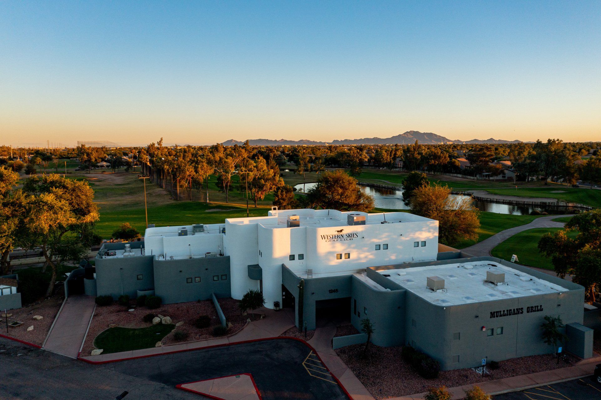 An aerial view of a large white building with a golf course in the background.