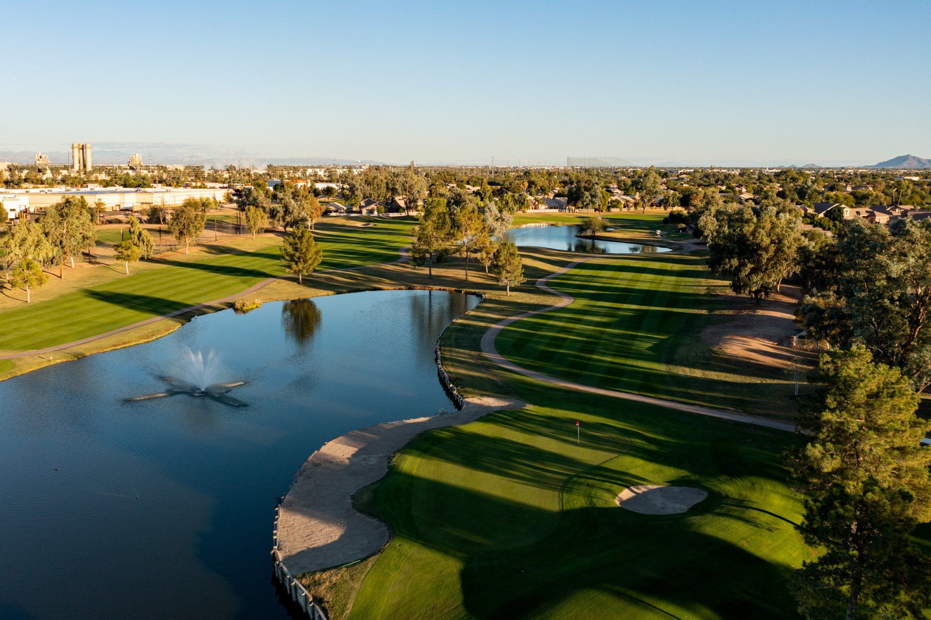 An aerial view of a golf course with a lake in the middle.