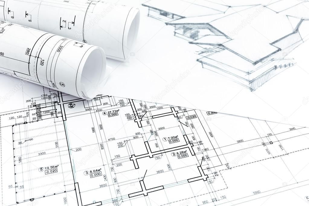 A couple of rolls of architectural drawings on a table.