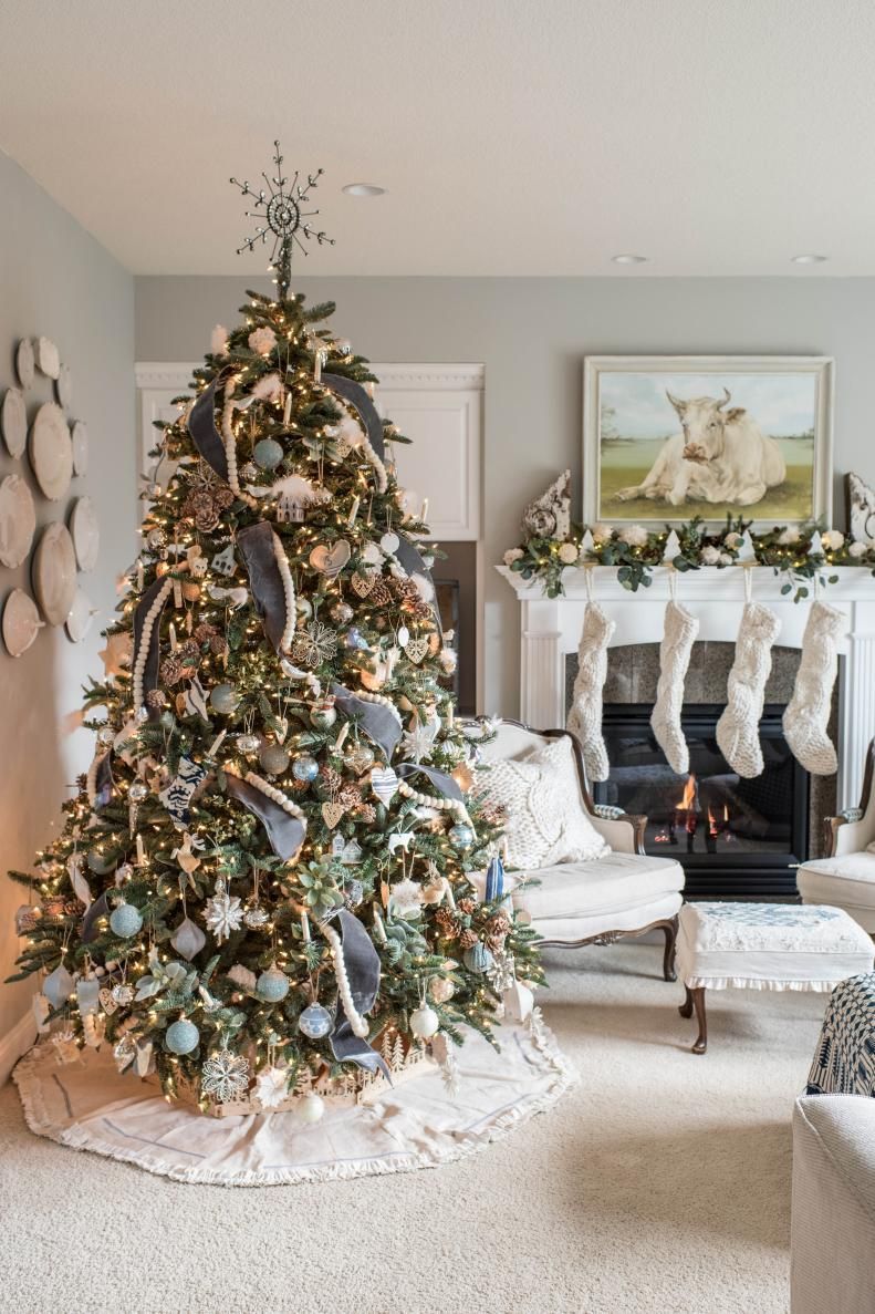 A christmas tree is sitting in a living room next to a fireplace. A christmas tree is sitting in a living room next to a fireplace.