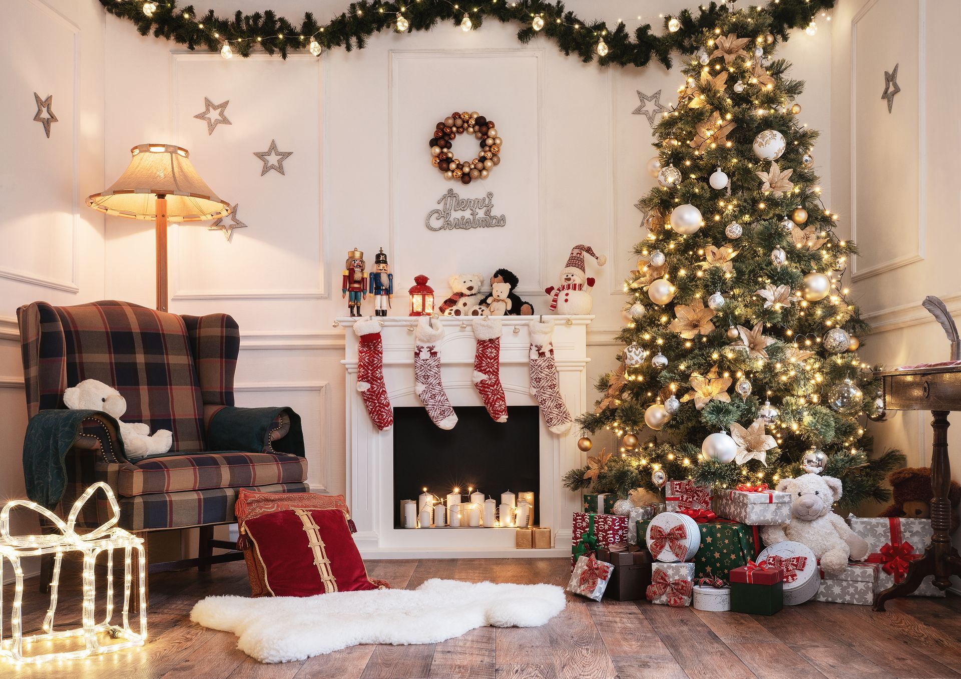 Festive porch with red door, garland, and wreath. White pillars and railing; windows with Christmas trees inside.