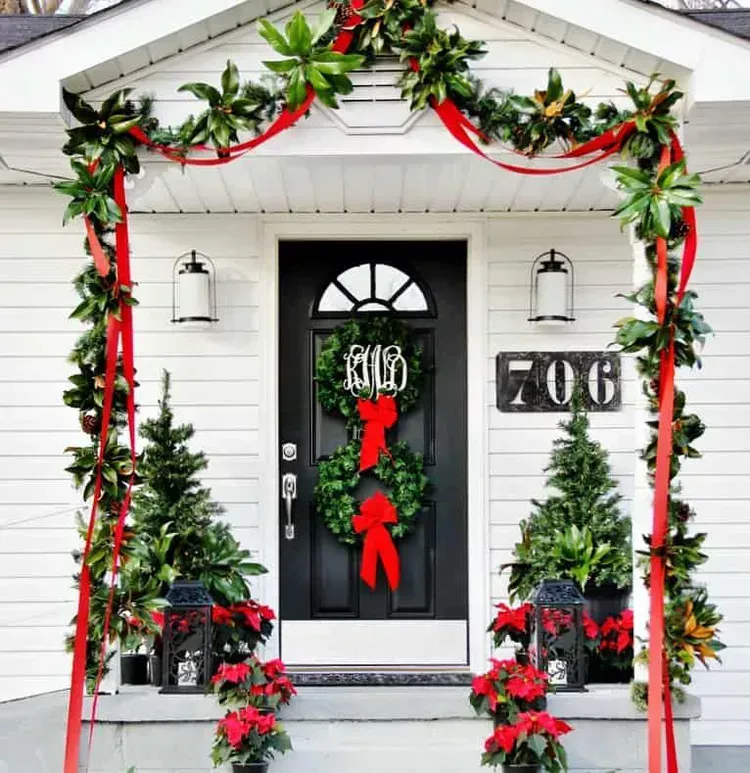 A white house with a black door decorated for christmas A white house with a black door decorated for christmas