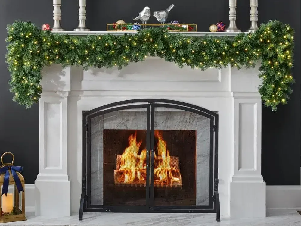 A fireplace with a wreath and candles on it. A fireplace with a wreath and candles on it