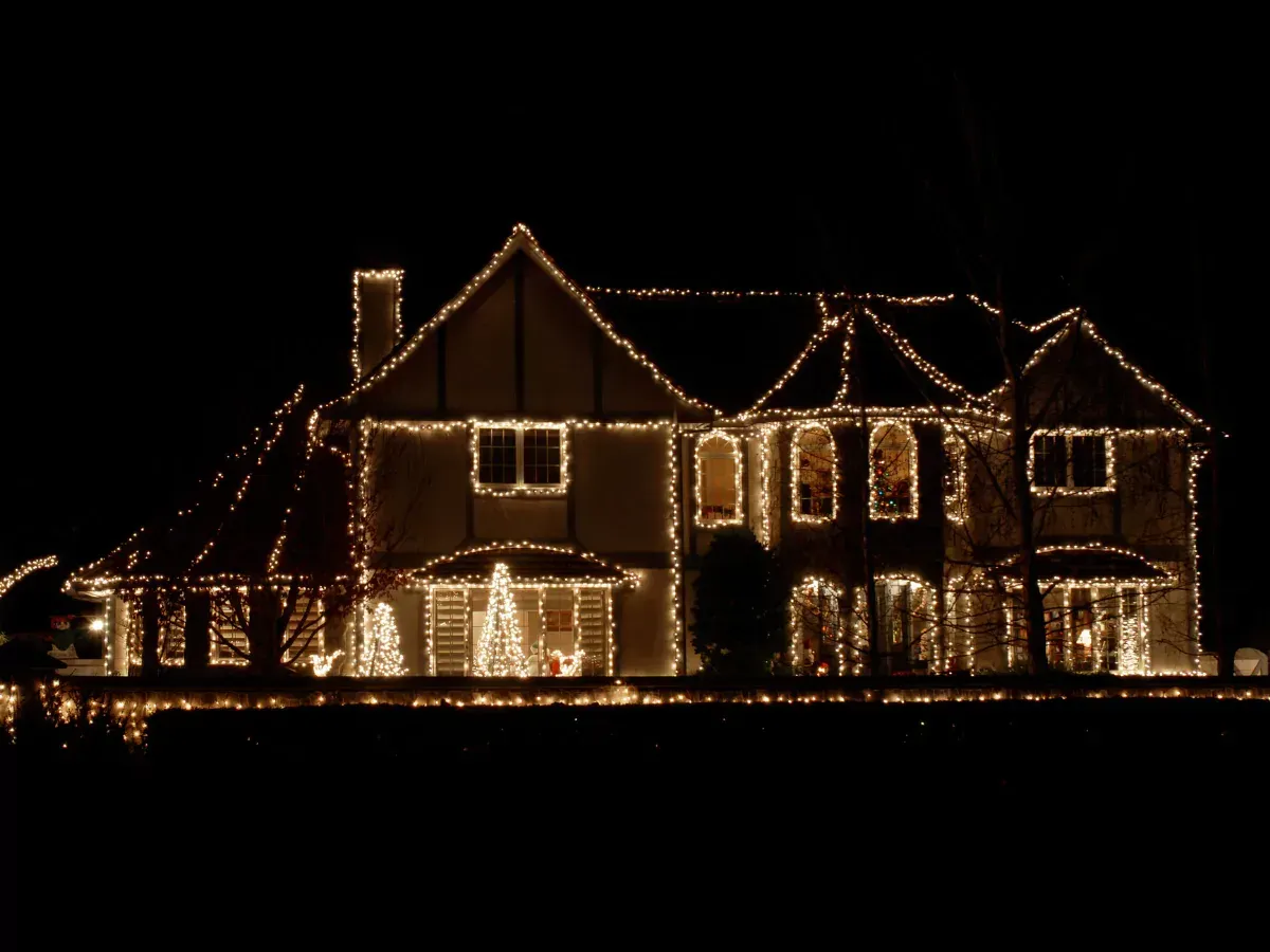 House decorated with warm white Christmas lights at night.