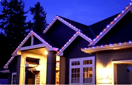 A house with christmas lights on the roof at night