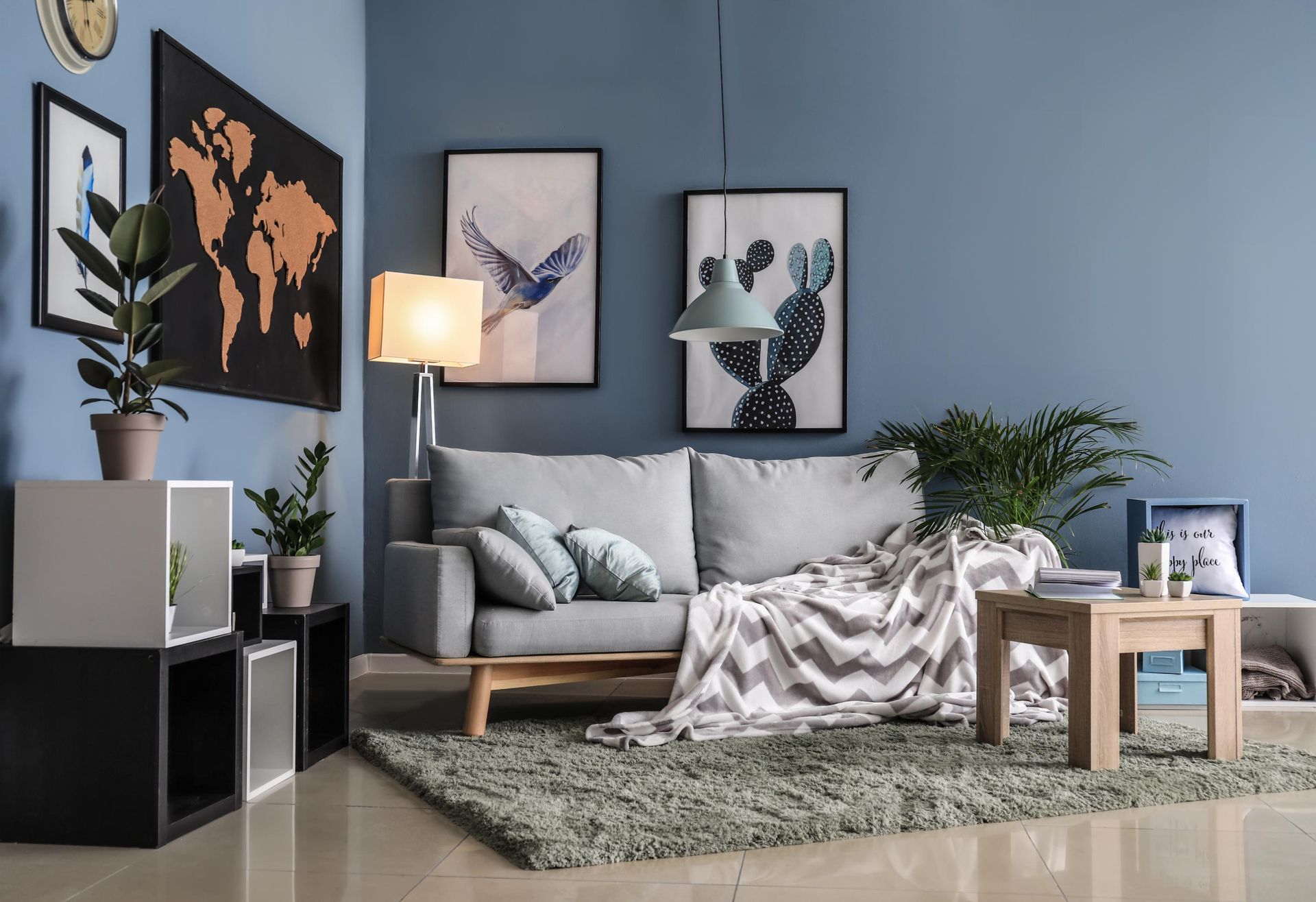 Living room with blue walls, gray sofa, and decorative artwork.