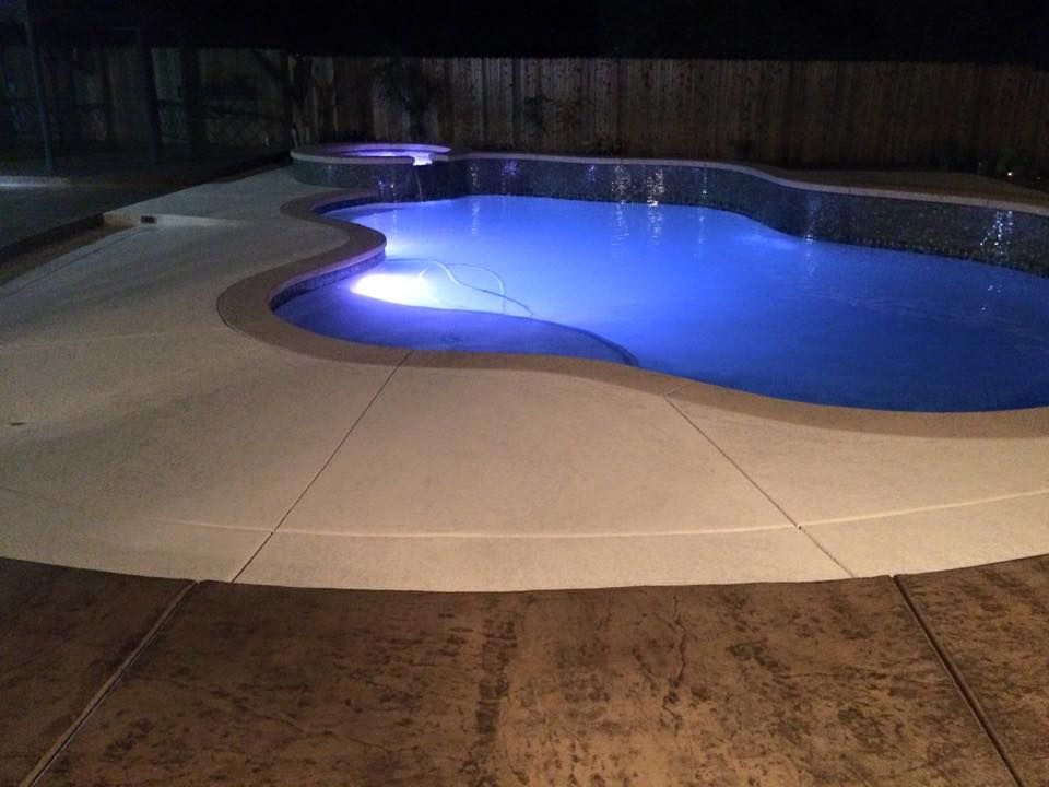 A large swimming pool is lit up at night