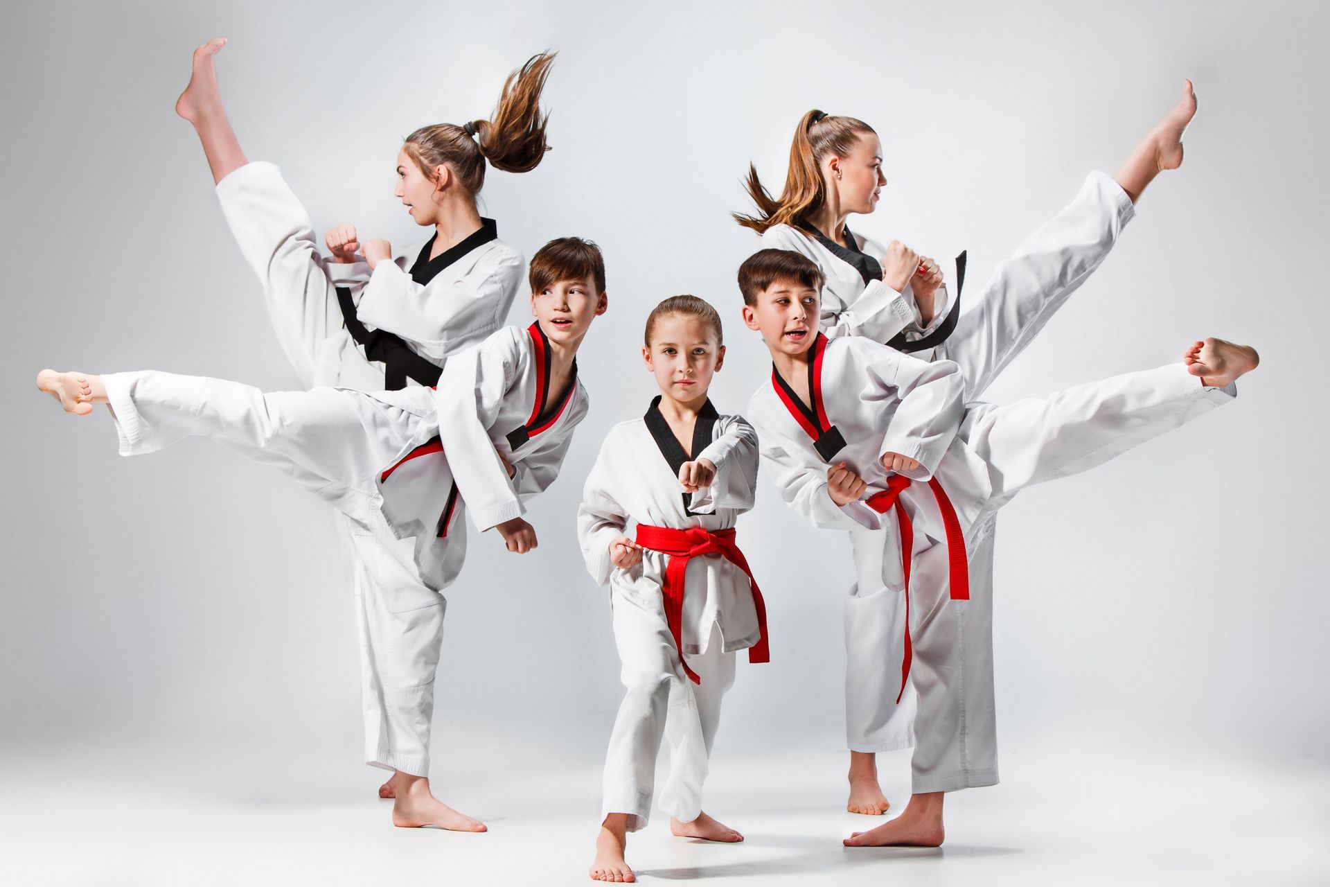A studio shot of a group of kids practising karate martial arts.