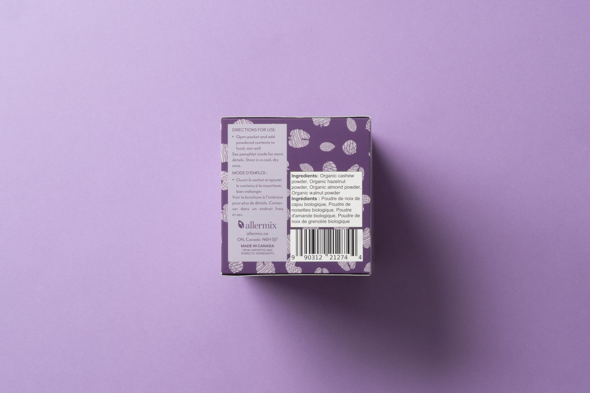 Small purple patterned product box with a white label and barcode on a lavender background.