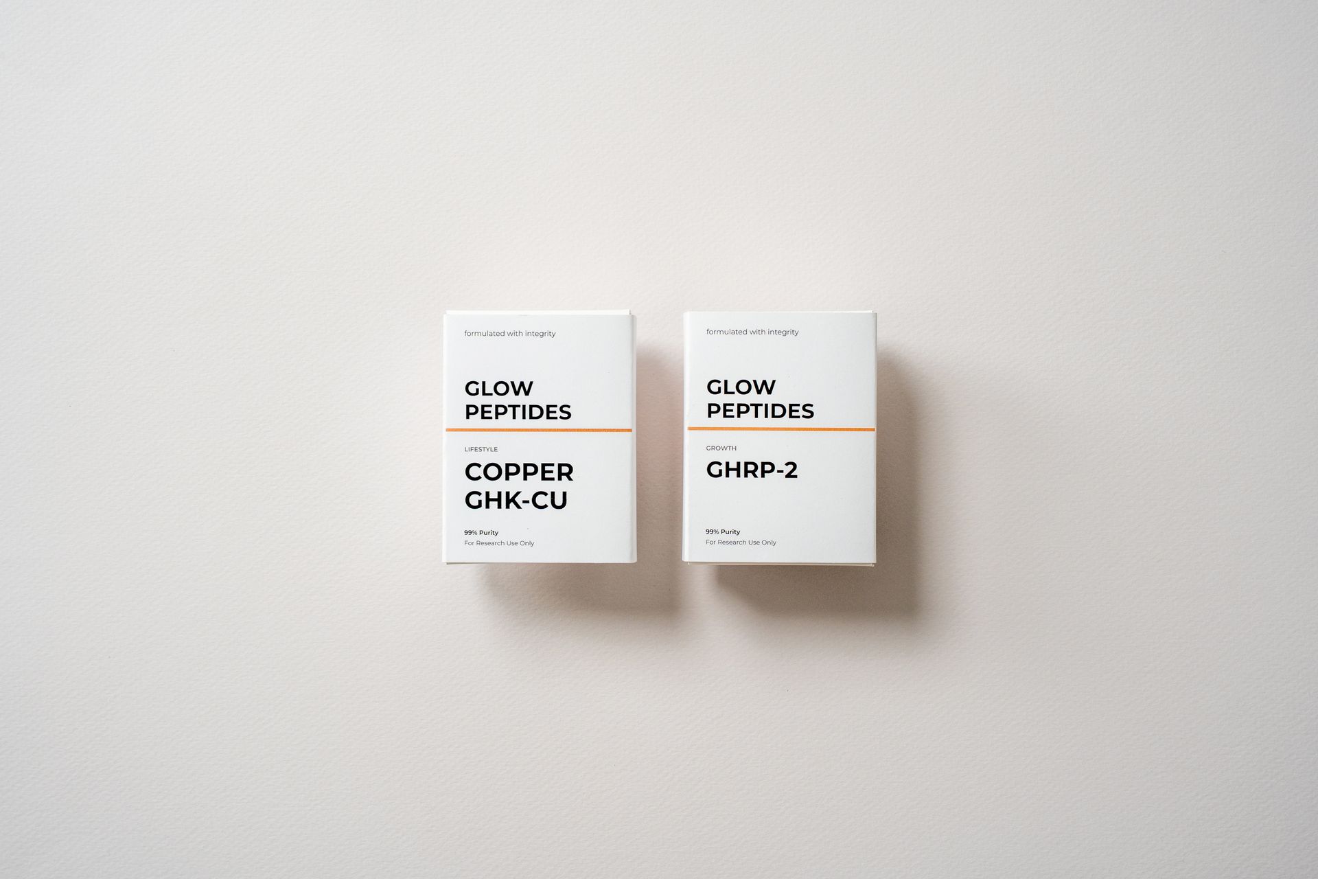 Two white GLOW PEPTIDES product boxes, one labeled GHK-P2 and one COPPER GHK-CU, on a light background