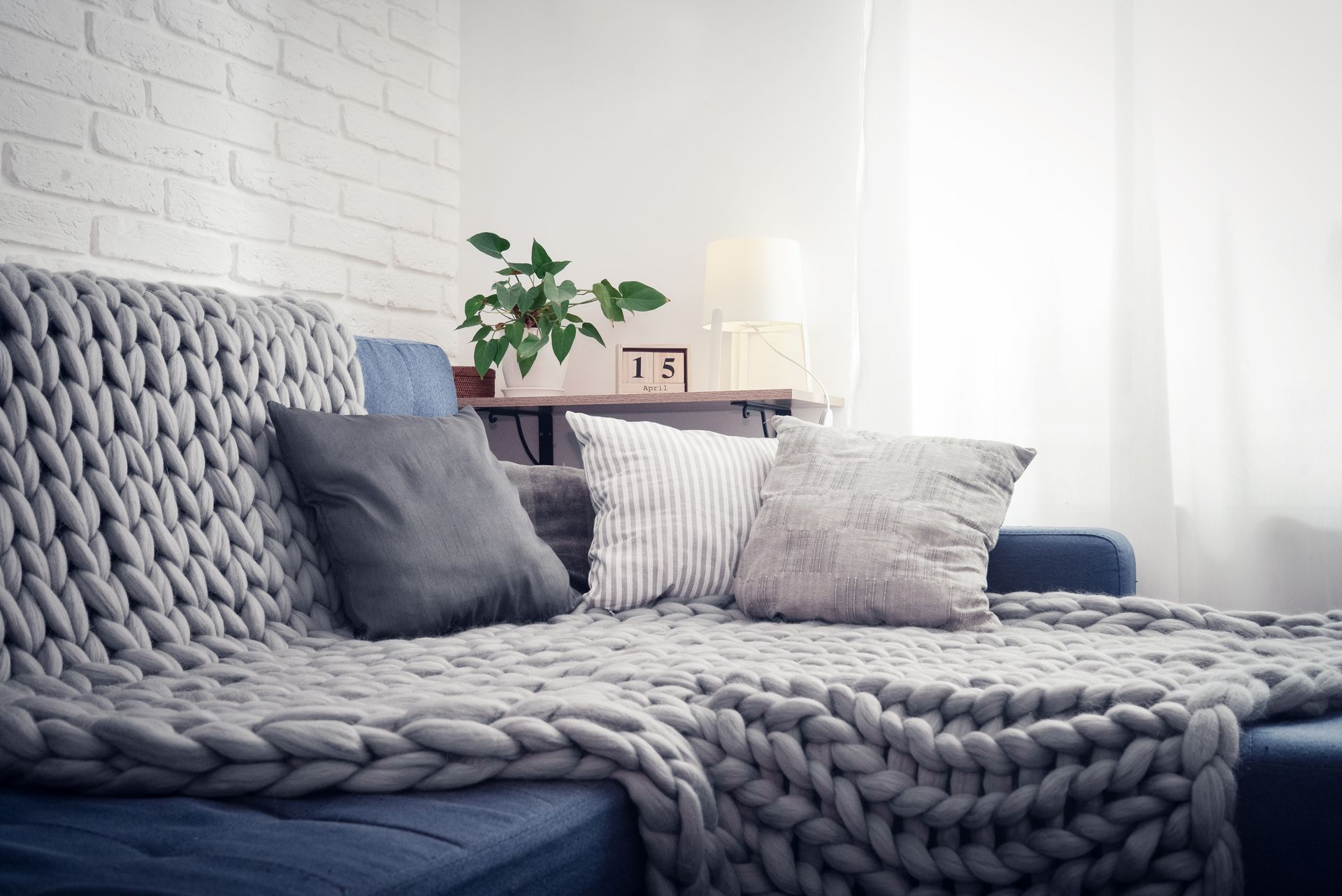Stock photo of a blue couch with a soft weighted blanket