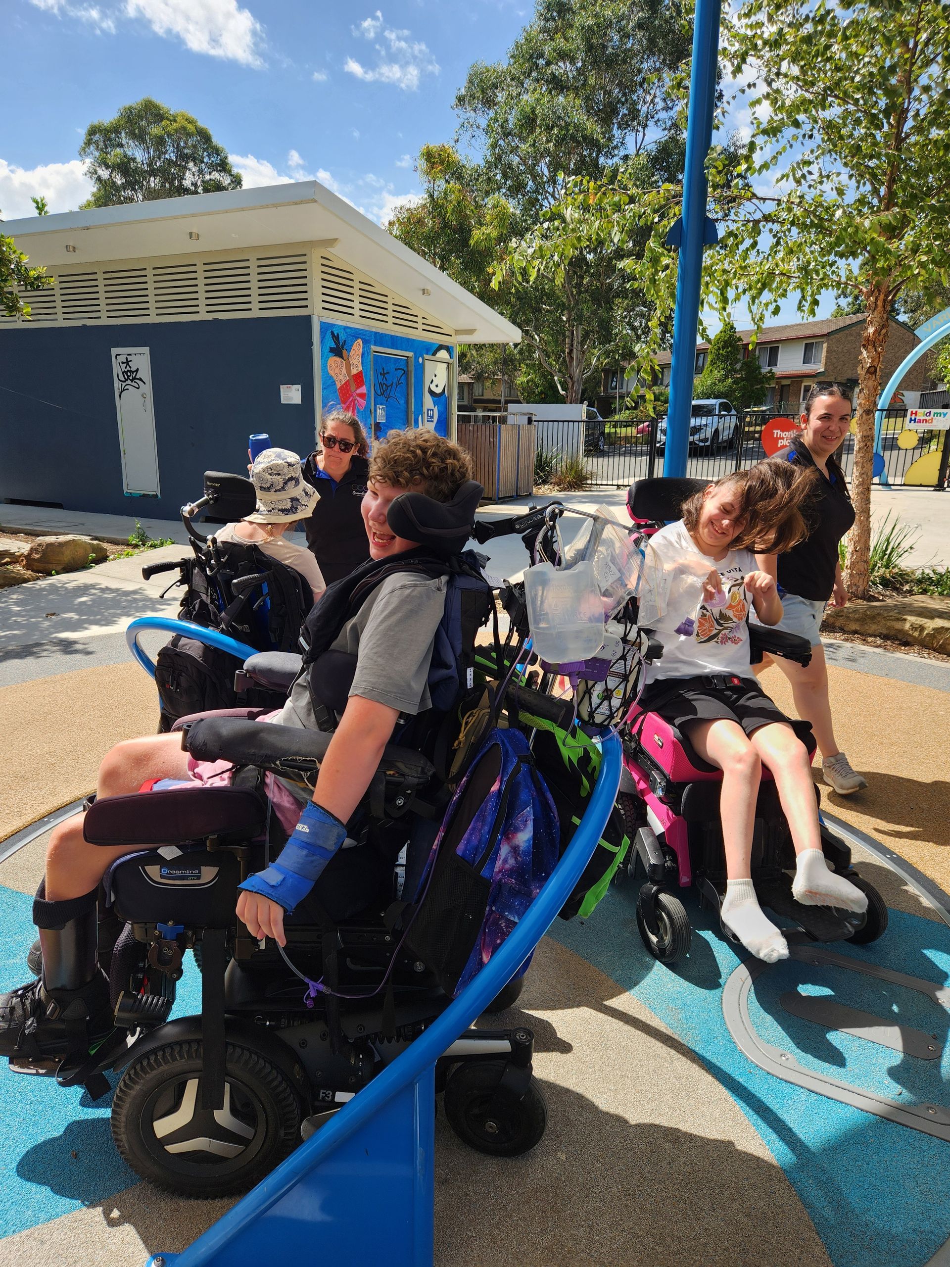 A group of young adults in wheelchairs on a merry go round