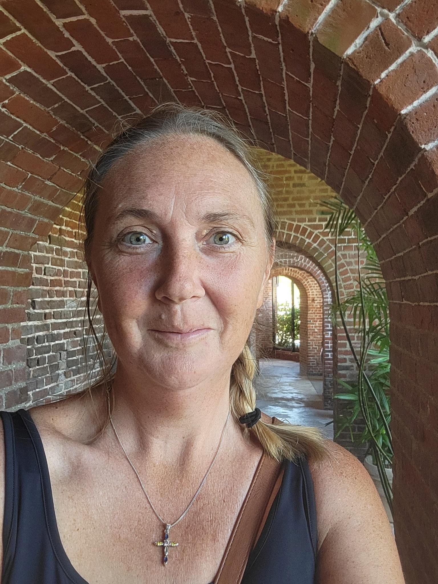 Woman smiling in front of brick archway