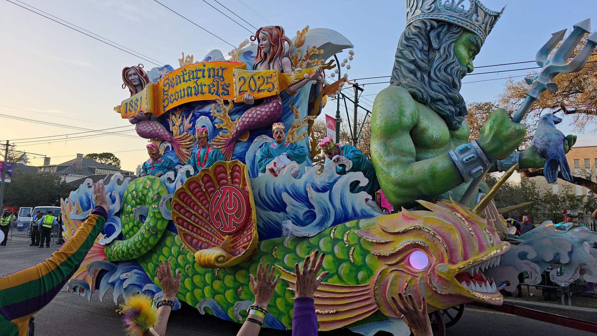 A parade with a float that looks like a dragon and a mermaid.