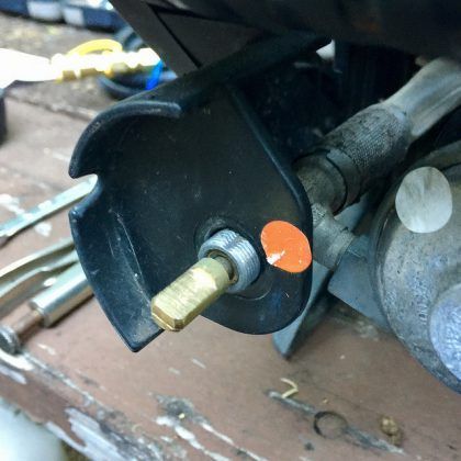 A close up of a metal object with an orange sticker on it.