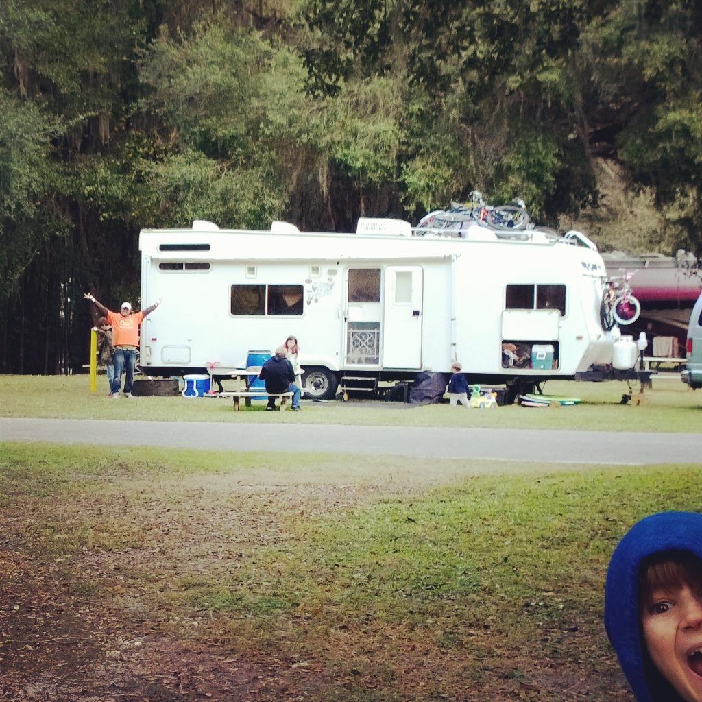 A group of people are standing in front of a rv
