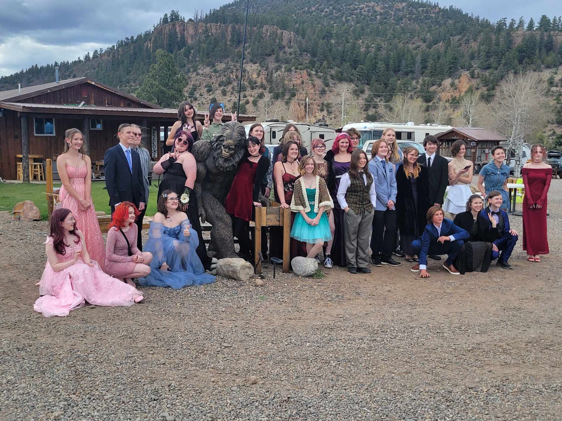 A group of people are posing for a picture in front of a mountain.